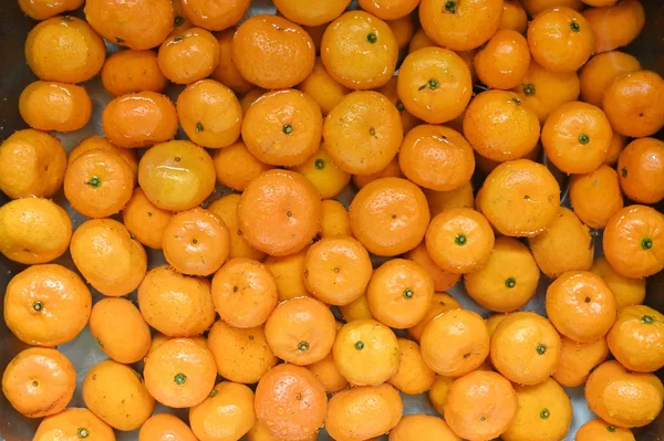 Pomarańczowe owoce myjące w zlewie dla tekstury i tła. — Zdjęcie stockowe