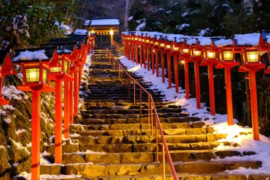 The lantern-lined steps in winter snow in Kibune at night clipart