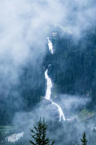 Avusturya 'da bulutlu ve sisli bir günde Krimmml Şelaleleri' nin uzak manzarası. Avrupa 'nın en yüksek şelalesi