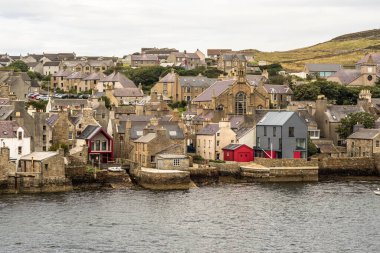 İskoçya, Orkney 'deki tarihi Stromness köyü. Hoy Sound 'daki balıkçı kasabasının deniz manzarası