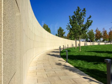 Park yolu taştan fayanslarla kaplı. Çim ve diğer bitkiler