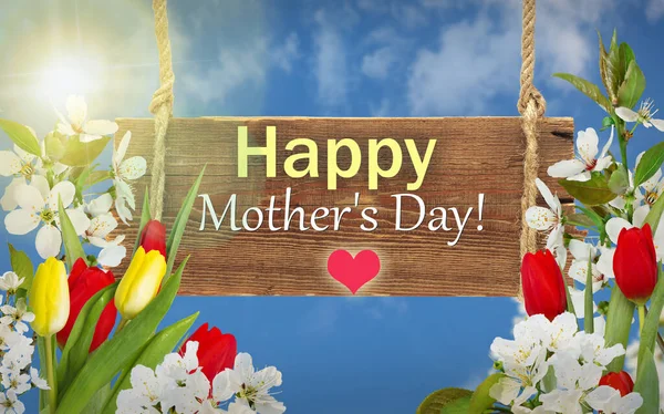 Diğerlerinin gününde kırmızı laleler ve kiraz çiçekleriyle dolu tebrik kartı, mavi arka planda bokeh