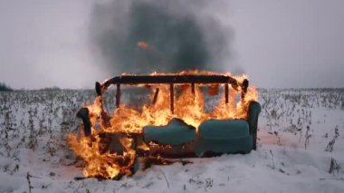 Kış tarlasında bir kanepe yanıyor. Mobilyalar yanıyor. Video yangını kanepeyi yok etti. Kanepe kış tarlasında yanıyor.