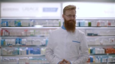 Genç bir eczacının portresi kameraya bakar ve avuçlarını çaprazlar.