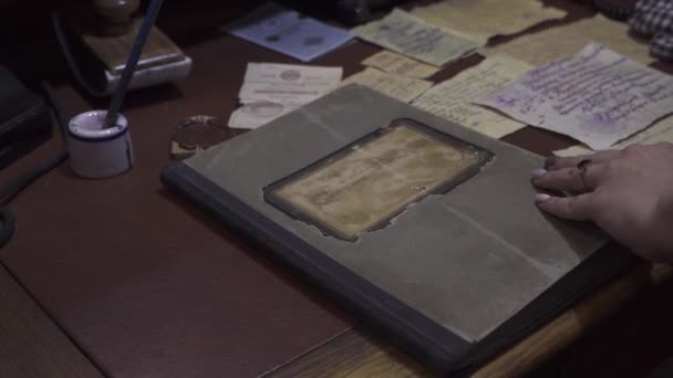 一只女手打开一本旧书.附近有墨水、钞票和其他古老的东西 — 图库视频影像