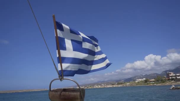 Vista de la bandera griega desde el barco. La orilla es visible en el fondo — Vídeos de Stock