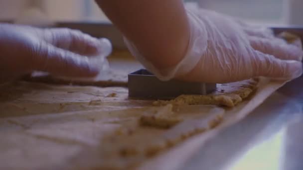 Ένας άντρας κόβει ένα ορθογώνιο μπισκότο στη ζύμη. Πλευρική όψη σε πρώτο πλάνο — Αρχείο Βίντεο