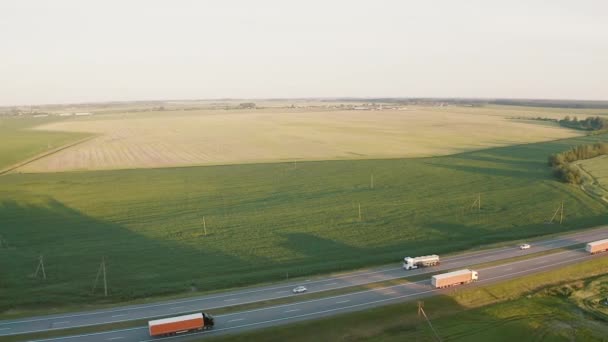Camiones en la puesta de sol de la carretera. Vista superior aérea — Vídeos de Stock