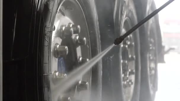 Worker in protective overalls washes truck with water — Stock Video