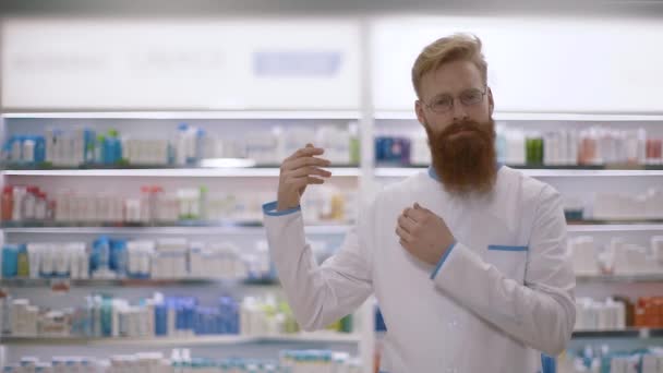 スローモーション。商品を指摘している若いハンサムな白人または北欧の薬剤師の肖像。右側 — ストック動画
