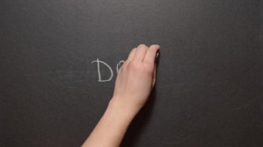 Üzülme, mutlu ol. Sol bir kadın eli siyah bir tahtaya renkli tebeşirle 