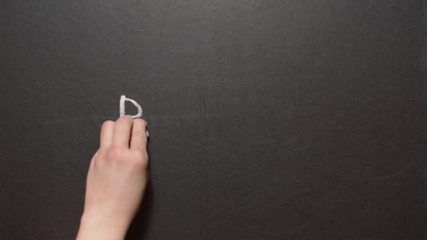 Stoppa rasismen. En vänster kvinnlig hand skriver ordet "rasism" med krita på en svart tavla och efter att ha slagit ut den med vit krita. Konceptuell kritritning — Stockvideo