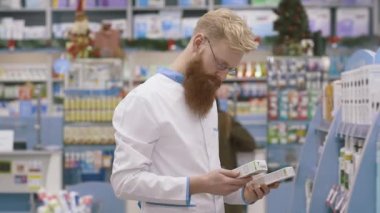 Büyük eczanesinde çalışan genç bir eczacı. İlaç envanterini çıkarıyorum. İlaç, ilaç, sağlık hizmetleri ve insanlar konsepti