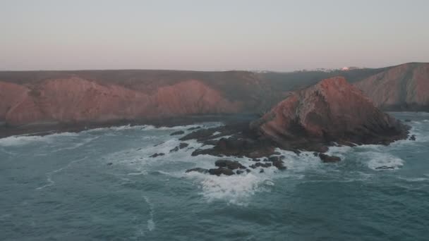 Filmvetítés drónfelvételeken gyönyörű sziklákról Portugália partjainál a Sunseten. Hullámok törnek a sziklák lábánál. Látványos kilátás az óceánra és a hegyekre — Stock videók