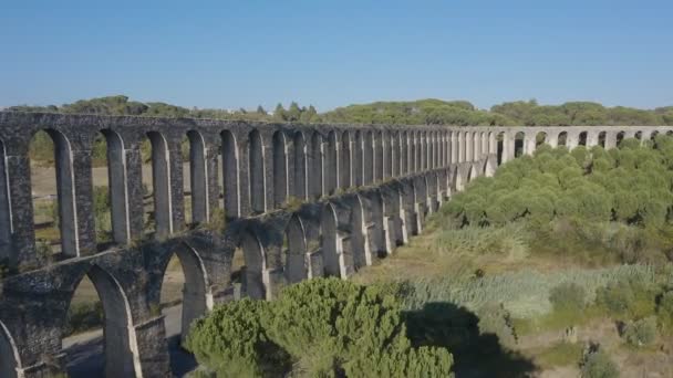 Antiguo acueducto de Pegoes cerca de Tomar, Portugal al atardecer. Vista aérea. Ruinas antiguas rodeadas por un bosque verde — Vídeo de stock