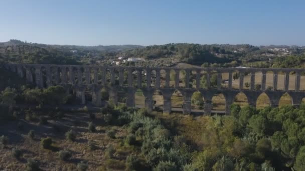 Vuelo sobre un antiguo acueducto portugués de Pegoes. Europa Dolly disparó. Sol al atardecer con destello de lentes. Ruinas antiguas rodeadas por un parque verde — Vídeos de Stock