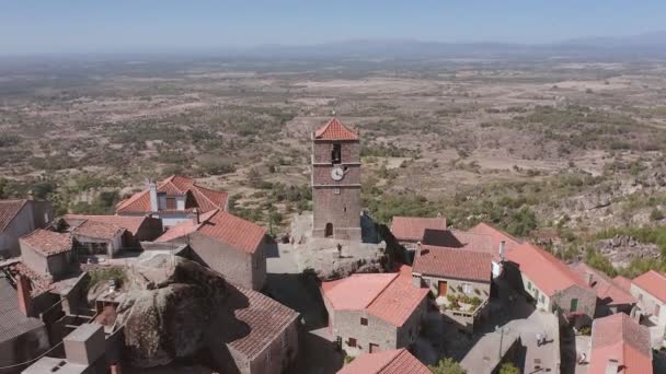 Αεροφωτογραφία του πύργου του ρολογιού Torre de Lucano στο αρχαίο παραδοσιακό χωριό Monsanto στην Πορτογαλία. Το drone σηκώνεται και ανοίγει ένα πανόραμα της κοιλάδας, αποκαλύπτοντας shot — Αρχείο Βίντεο