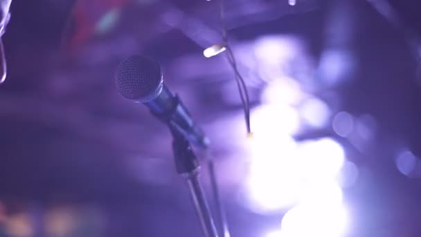 Hombre cantando canción en el micrófono durante la actuación en el escenario en el concierto de rock. Primer hombre cantante estrella de rock en concierto de música sobre fondo de luz colorida — Vídeos de Stock