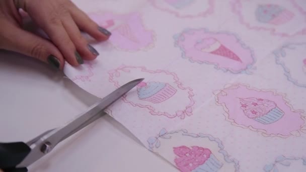 Scissors cut the fabric with a bright and colorful pattern. Close-up. — Stock Video