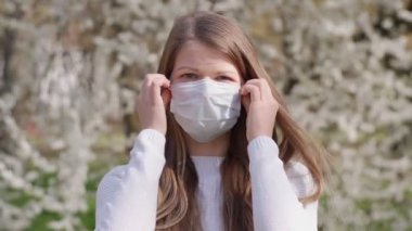 Genç kadın tıbbi maskesini çıkarıyor. Kız kameraya bakarak derin derin nefes alıyor ve gülümsüyor. Çiçek açan bir ağaç şeklinde bir arkaplan. Bahar. Kız, salgının ve karantinanın sona ermesine seviniyor.