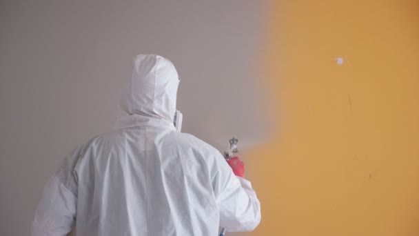 Oprava bytu. Profesionální malíř maluje stěny s bílou stříkací pistolí. — Stock video