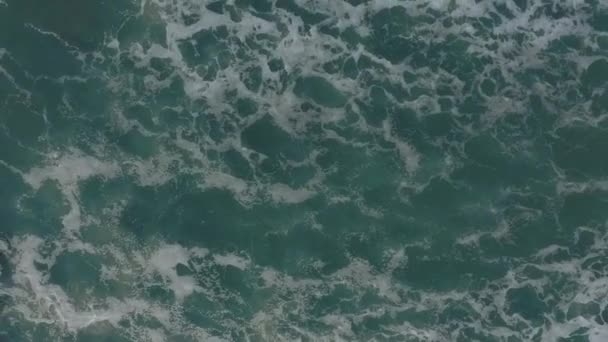 Große Wellen rollen von oben. 4k Drohnenblick von oben auf den türkisblauen Ozean, brechende Wellen, Tünche. Sonniger Tag über dem Meer. Riesiger Wellengang trifft Küste. — Stockvideo