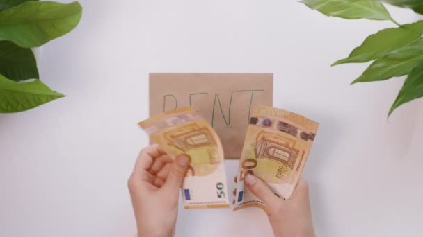Handen tellen euro en plakken het dan op een enveloppe met de inscriptie Rent. — Stockvideo