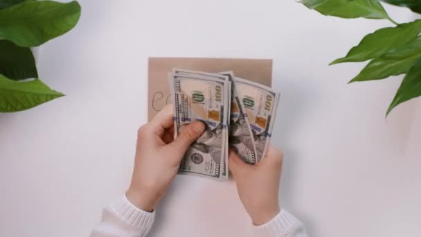 Handen tellen geld en doen het dan op een enveloppe met een inscriptie Onderwijs. Het meisje spaart geld voor onderwijs.. — Stockvideo