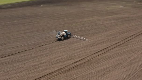 Воздушное изображение тракторного распыления сельскохозяйственного поля. Современное сельское хозяйство. Сельскохозяйственные работы по подготовке к посеву . — стоковое видео