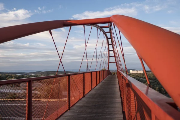 design elevated red bridge over the highway without people on cloudy day