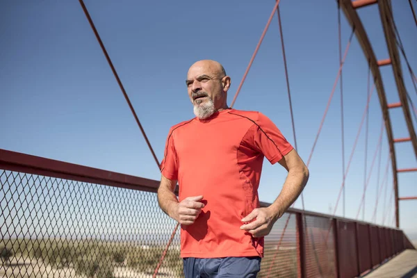 Senior runner training on a bridge