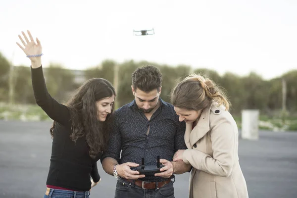 A group of friends controlling mini drone in park