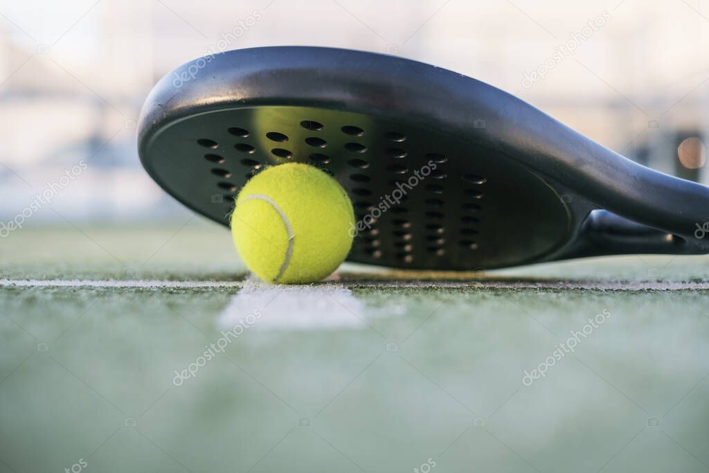Closeup view of paddle tennis objects in court, racket and ball