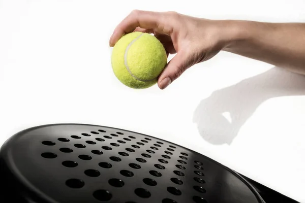 Paddle tennis ball and racket on white background, outdoors image