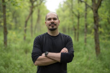 Çekici kel adam ormanda yürüyüş yapıyor.