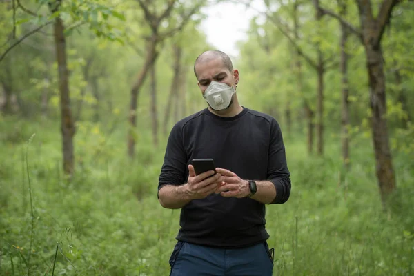 man in the forest with sanitary mask to avoid contamination, allergy or virus