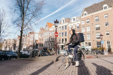 Genç adam strret Amsterdam bir bisiklet sürme