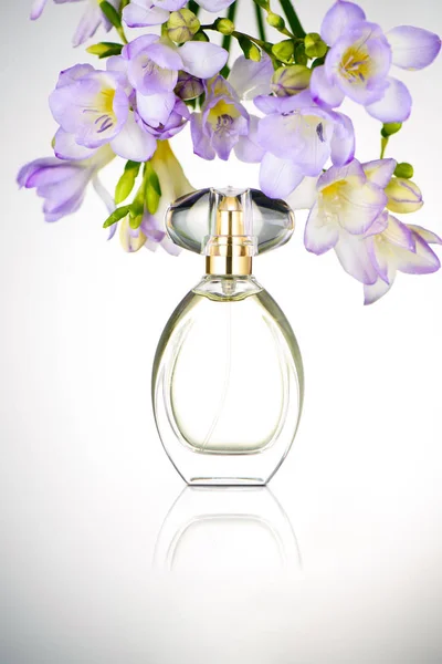 Bottiglia di profumo con fiori viola — Foto Stock