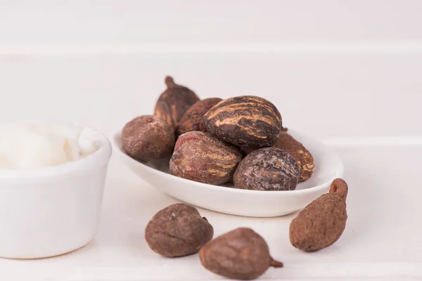 Орехи маслом Ши на белом столе — стоковое фото