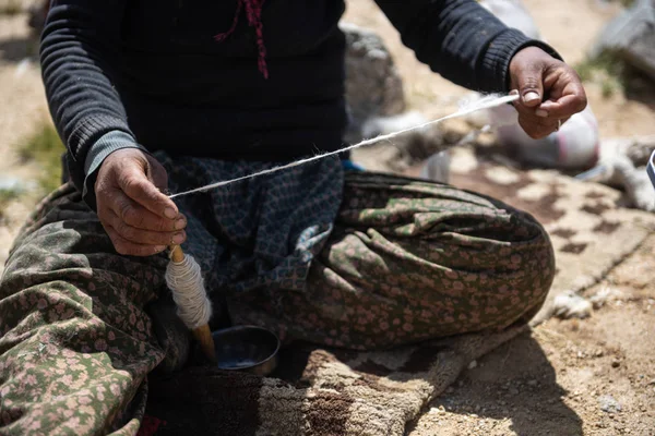 Mains d'une femme filant des fibres de laine — Photo