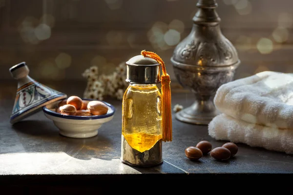 Bottiglia di olio di Argan su un tavolo con frutta — Foto Stock