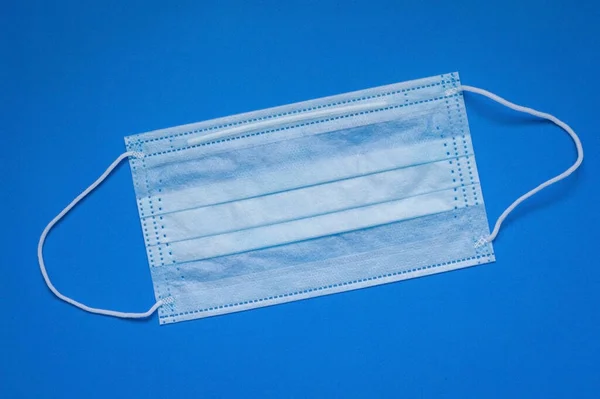 Mavi arka planda tek kullanımlık tıbbi maske..