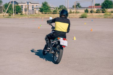 Motosiklet sürmeyi öğrenme platformu. Motosiklet okulunda dersler. Yetişkinler için bisiklet sürme kursu. Adam bisiklet sürmeyi öğreniyor. Eğitim sahasında sürüş becerilerini geliştir