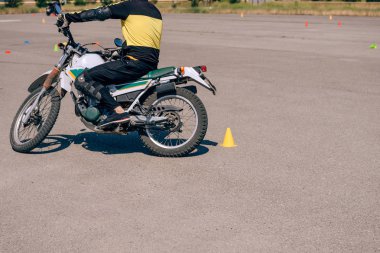 Motosiklet sürmeyi öğrenme platformu. Motosiklet okulunda dersler. Yetişkinler için bisiklet sürme kursu. Adam bisiklet sürmeyi öğreniyor. Eğitim sahasında sürüş becerilerini geliştir