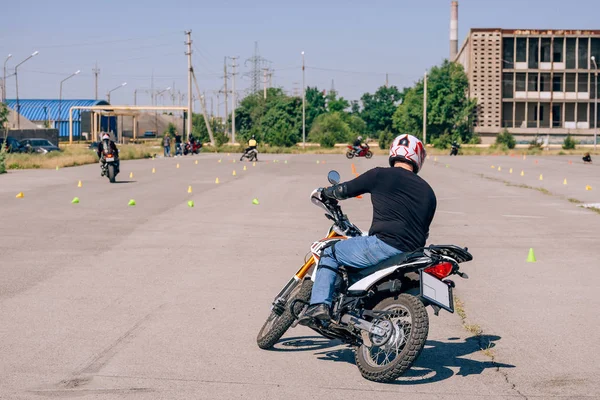 Platform for learning to drive a motorcycle. Lessons in motorcycle school.  Bike driving courses for adults. Man learn to drive a bike. Improve driving skills on the training ground