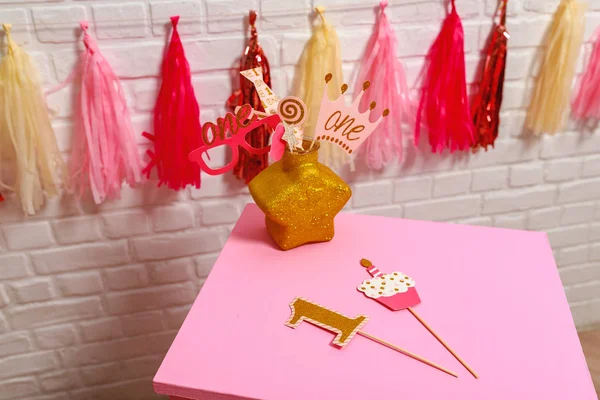 为小女孩布置粉色风格的第一年生日晚会的想法 白色砖墙上的纸制花环和照相亭的道具 时尚道具一年的摄影 — 图库照片