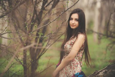 Baharın başında bir bahçede güzel bir genç kadının portresi. Huş ağacından bir korulukta açık renk elbiseli esmer kız. Esmer kız ormanda yürüyor