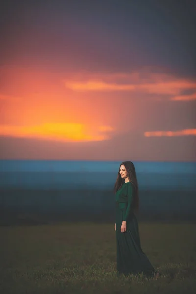 Hermosa Mujer Joven Vestido Verde Largo Sobre Fondo Del Atardecer — Foto de Stock