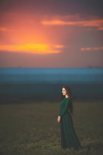 Hermosa Mujer Joven Vestido Verde Largo Sobre Fondo Del Atardecer — Foto de Stock