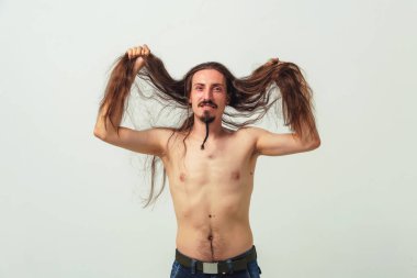 Beyaz arka planda çıplak gövdeli, uzun saçlı ve sakallı bir adam. Genç bir çocuğun uzun dalgalı saçları. Uzun erkek saçlarına dikkat et.